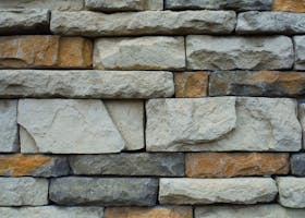 Close-up of a textured stone wall with a variety of natural colors.